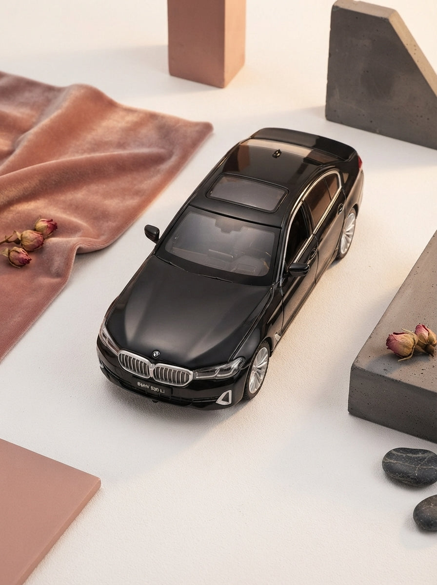 Black Mamba diecast alloy car displayed in a flat-lay arrangement with minimalist rose and charcoal accessories on a white su